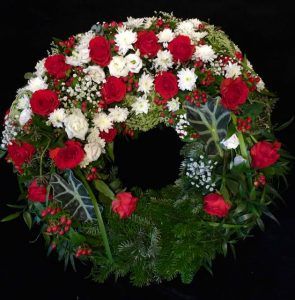 Trauerkranz mit roten und weißen Blumen